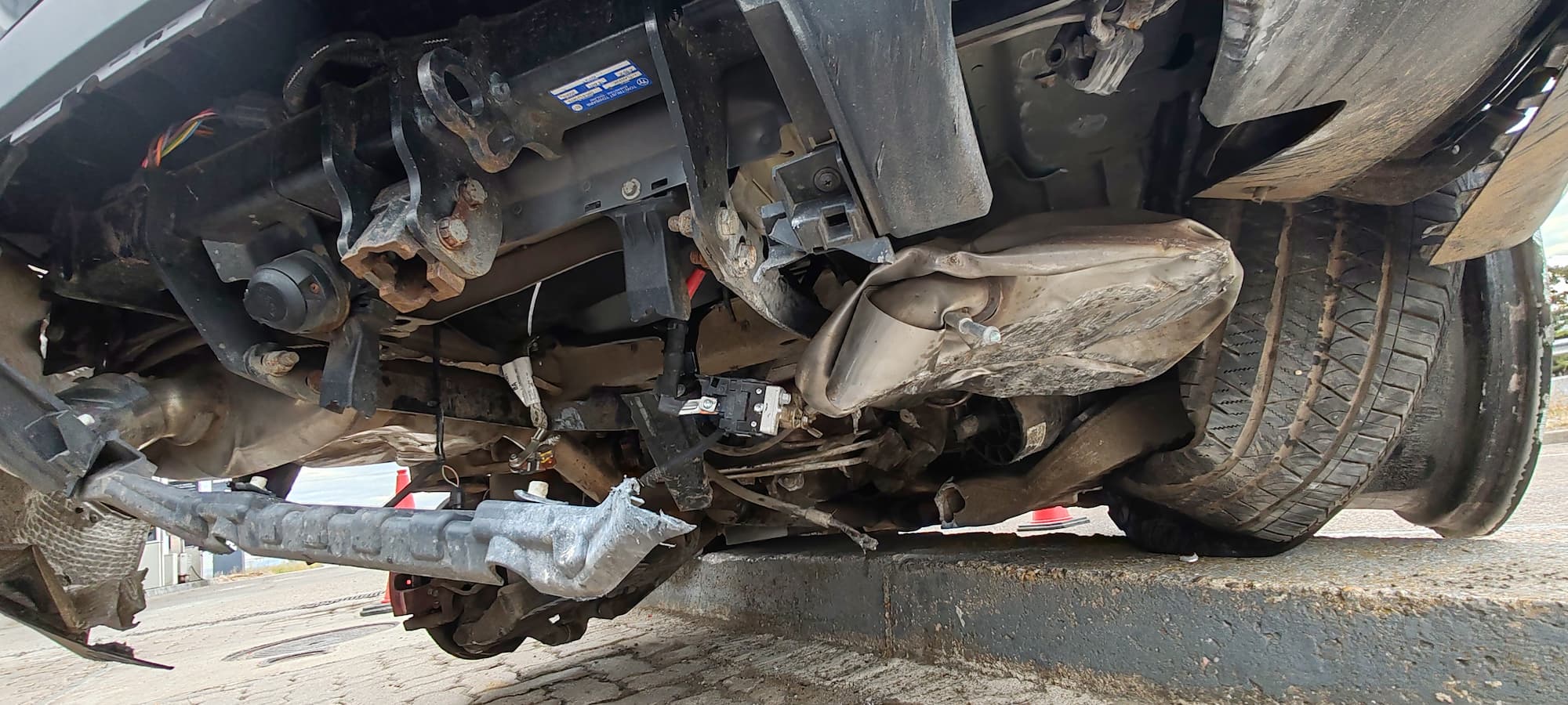 Close-up of the damaged rear suspension and detached wheel on the Range Rover Sport at the Repsol services in Spain